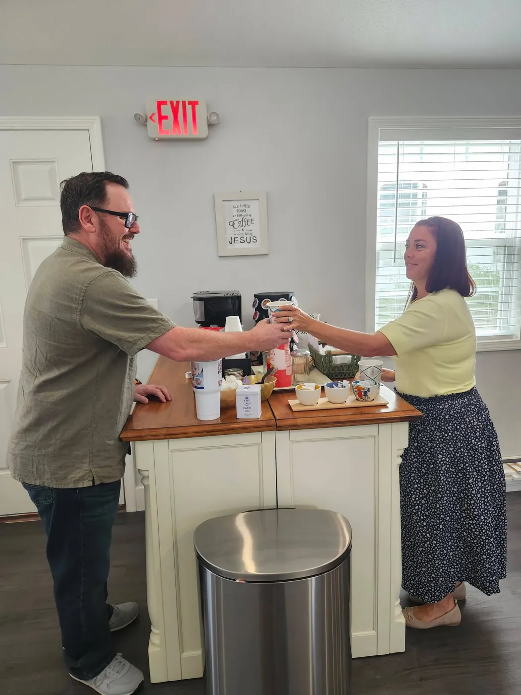 A cup of coffee handed across the counter in the Adkins Hall after the Sunday service