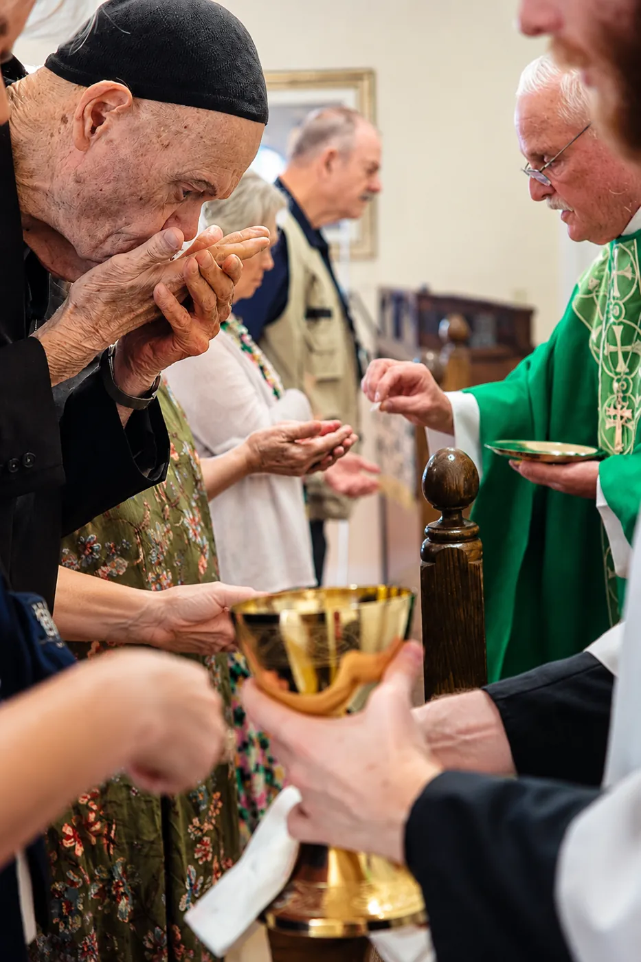 A communicant receiving the host at the altar rail, the chalice held ready