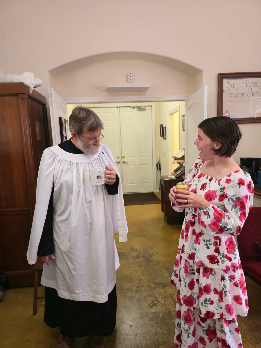 Fr. Mike laughing with a parishioner over coffee after the service